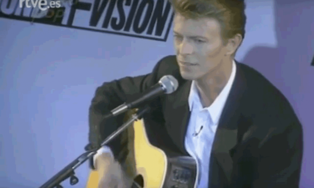 David Bowie plays acoustic guitar at the Sound & Vision tour press conference in 1990