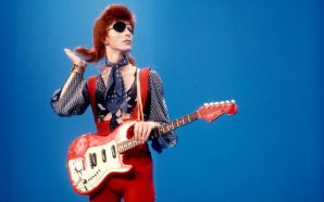 David Bowie poses with red Kent guitar wearing an eye patch