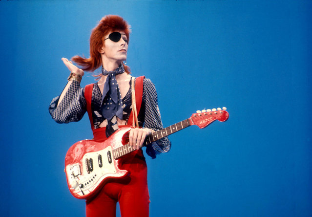 David Bowie poses with red Kent guitar wearing an eye patch
