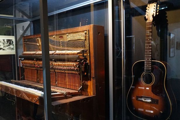 David Bowie's 12-string Hagstrom acoustic guitar on display at The Beatles Story next to John Lennon's piano