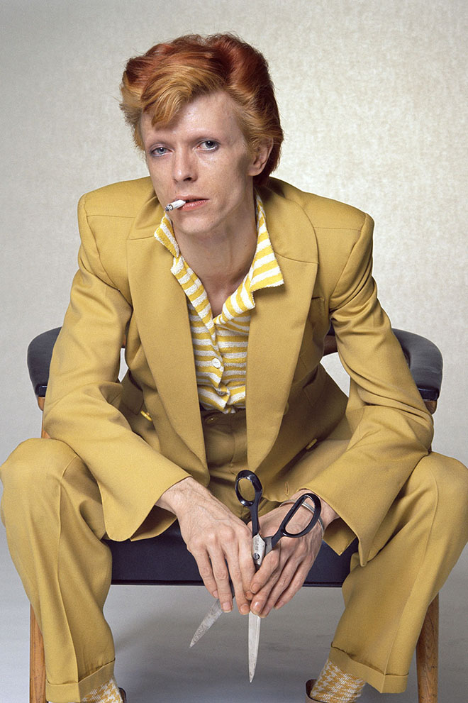 English singer, musician and actor David Bowie with dyed red hair and a mustard yellow suit photographed for a magazine in Los Angeles, circa 1974.